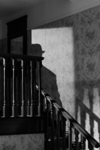 A mysterious noir scene with a detective's shadow on a vintage staircase.